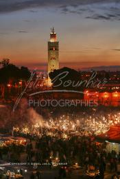 Image du Maroc Professionnelle de  Au coucher du soleil et même un peu avant la foule envahi la fameuse Place Jemaa El Fana qui se métamorphose en un gigantesque restaurant en plein air grâce aux nombreux stands et gargotes qui s'y installent sur ce lieu mythique au centre de la médina de Marrakech. Au fond le minaret de la Koutoubia, Samedi 26 Février 2005. (Photo / Abdeljalil Bounhar)

